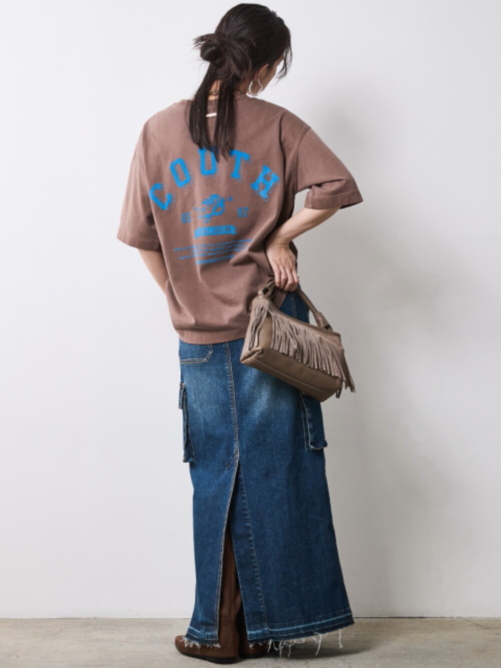 ブラウン系のTシャツ/カットソー、ブルー系のデニムスカートを着用したレディースの夏コーディネートの2枚目の写真