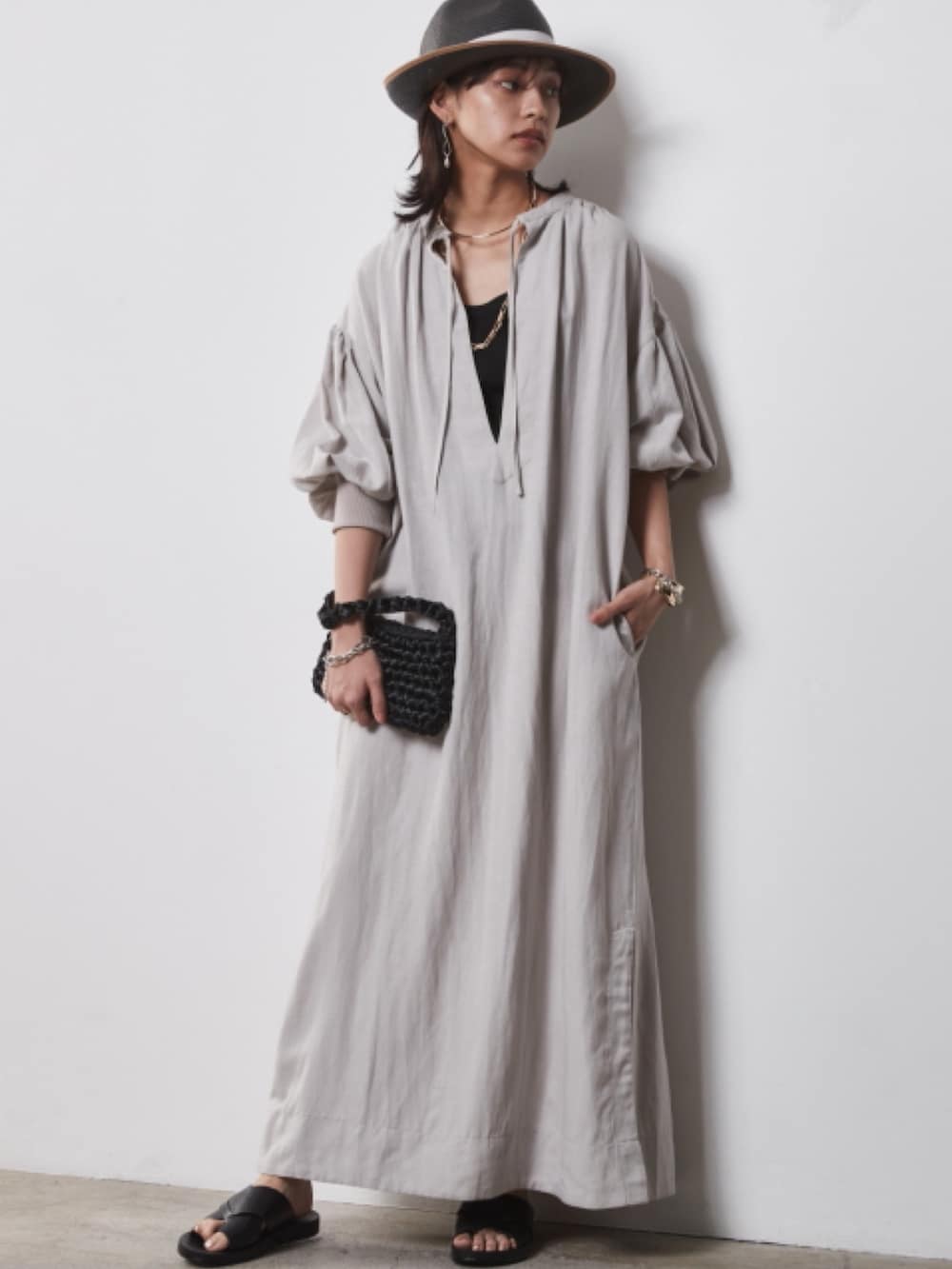 ブルー系のデニムパンツ、ベージュ系のワンピースを着用したレディースの春コーディネートの2枚目の写真