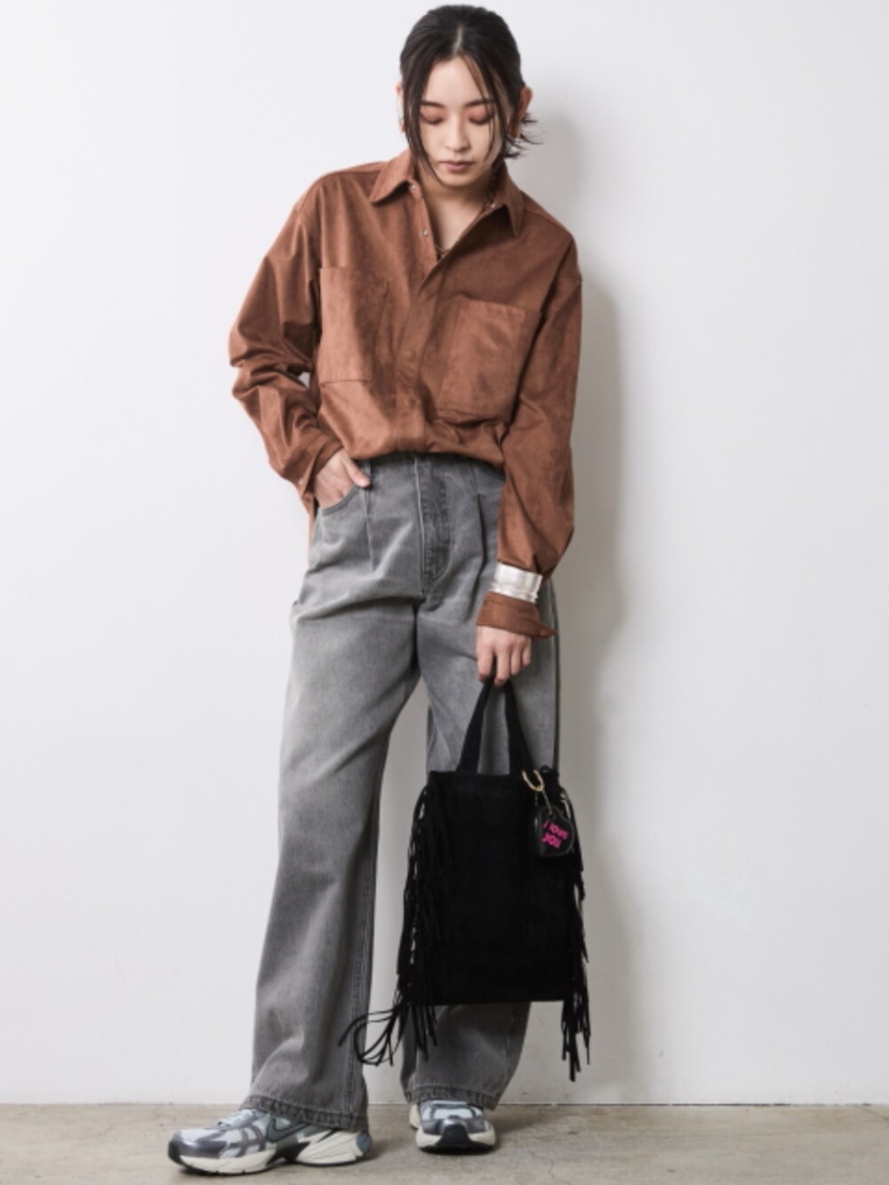 グレー系のデニムパンツ、ブラウン系のシャツ/ブラウス、グレー系のベストを着用したレディースの秋コーディネートの2枚目の写真