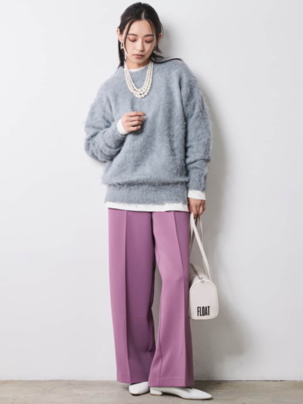 ブラック系のブルゾン、グレー系のニット/セーター、パープル系のスラックスを着用したレディースの秋コーディネートの2枚目の写真