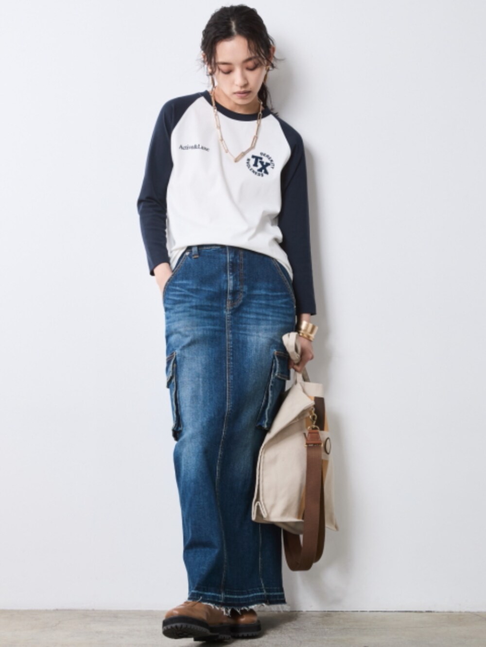 ホワイト系のTシャツ/カットソー、オレンジ系のスカジャン、ブルー系のデニムスカートを着用したレディースの夏コーディネートの2枚目の写真