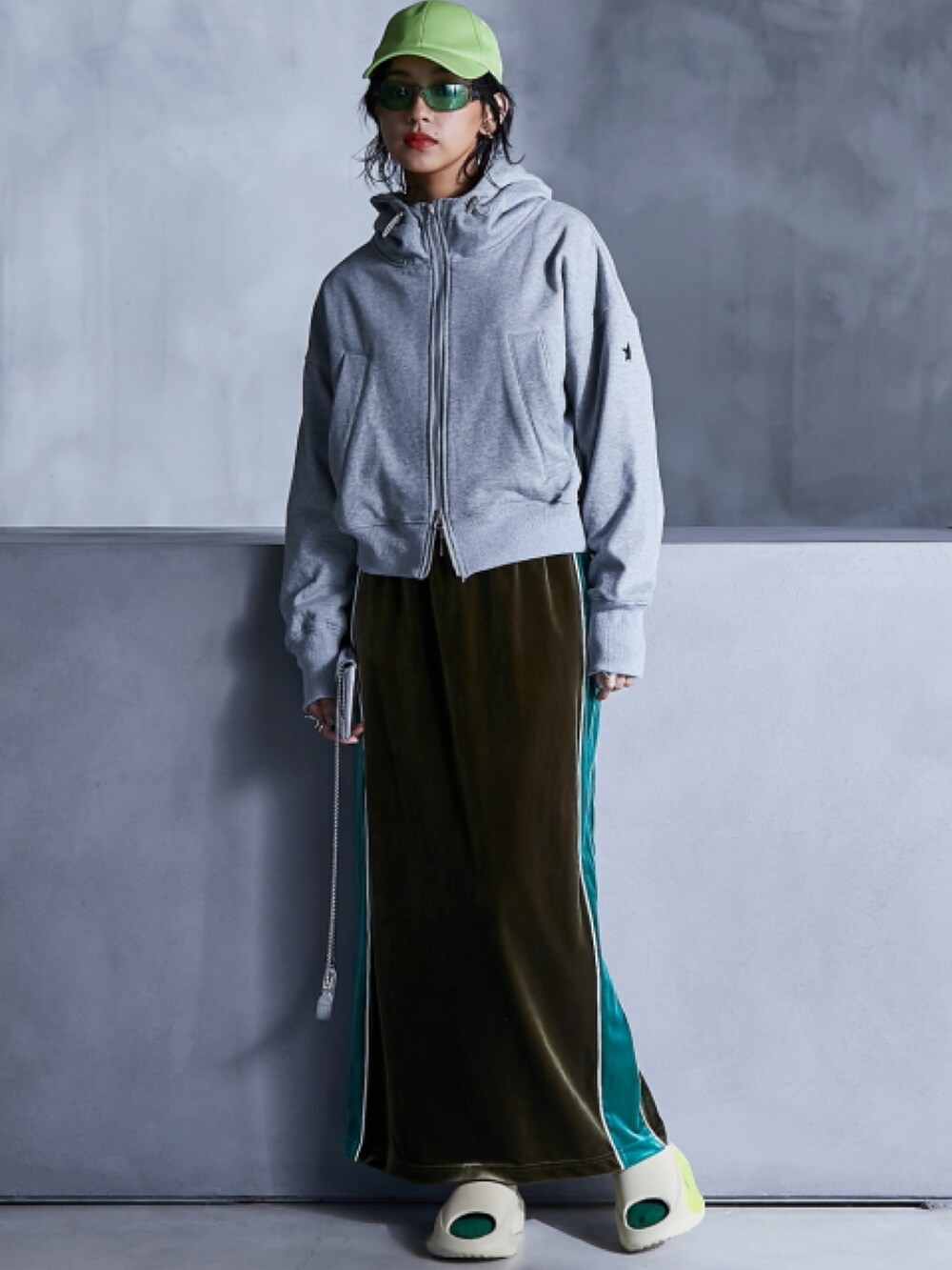 グレー系のパーカー、グリーン系のスカート、ホワイト系のTシャツ/カットソーを着用したレディースの秋コーディネートの2枚目の写真