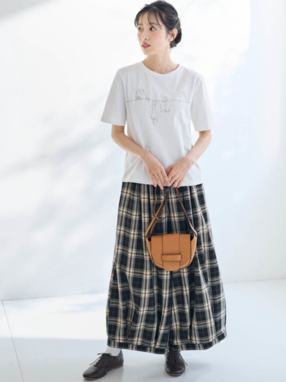 ブラウン系のパンツ、ホワイト系のTシャツ/カットソー、ブラック系のノーカラージャケットを着用したレディースの冬コーディネートの2枚目の写真