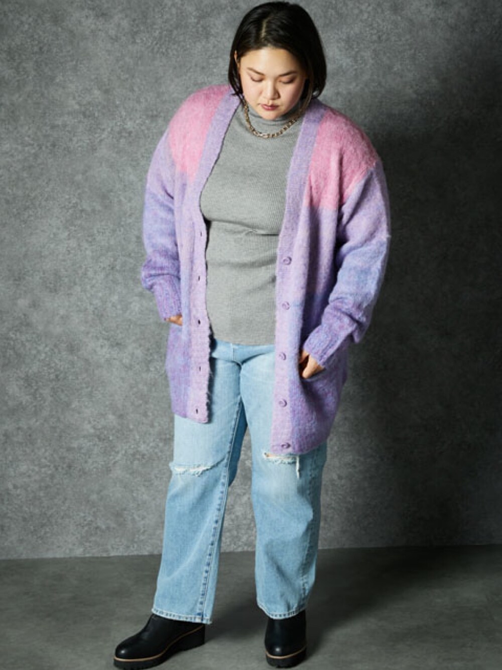 ピンク系のカーディガン/ボレロ、ブルー系のデニムパンツを着用したレディースの冬コーディネートの2枚目の写真