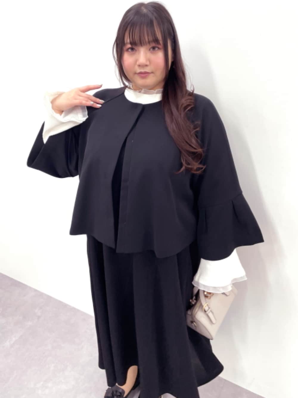 ホワイト系のTシャツ/カットソー、ブラック系のノーカラージャケット、ブラック系のワンピースを着用したレディースの冬コーディネートの2枚目の写真