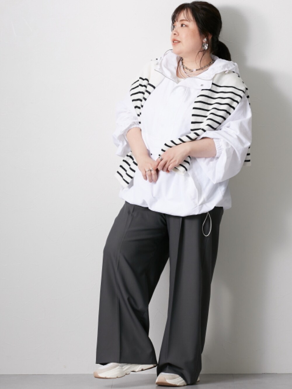 ホワイト系のニット/セーター、グレー系のパンツ、ホワイト系のジャケット/アウターを着用したレディースの冬コーディネートの2枚目の写真