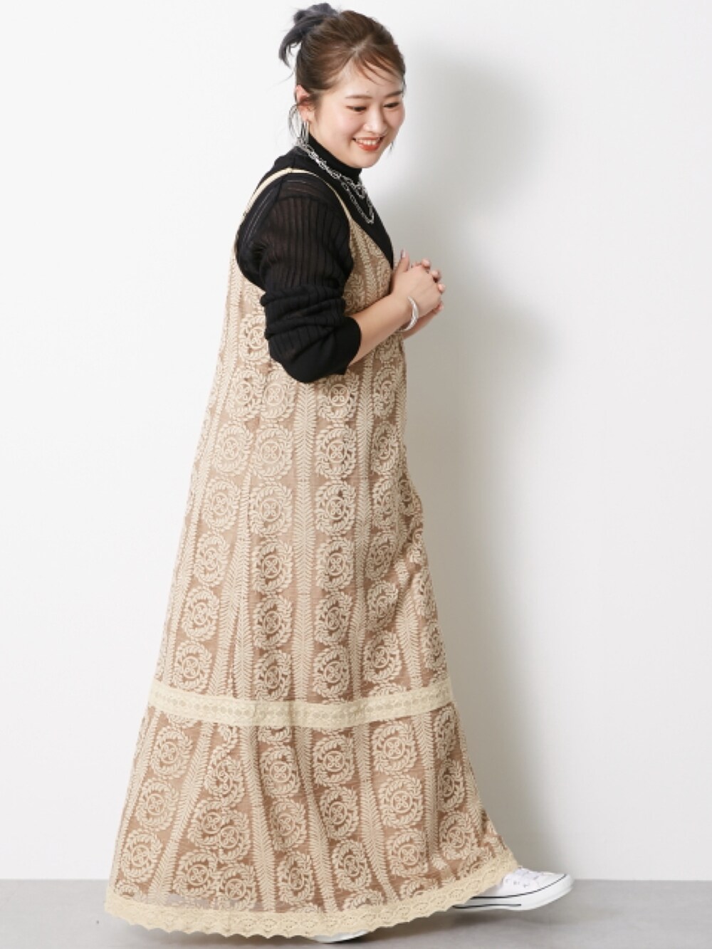 ブラック系のニット/セーター、ベージュ系のワンピースを着用したレディースの冬コーディネートの3枚目の写真