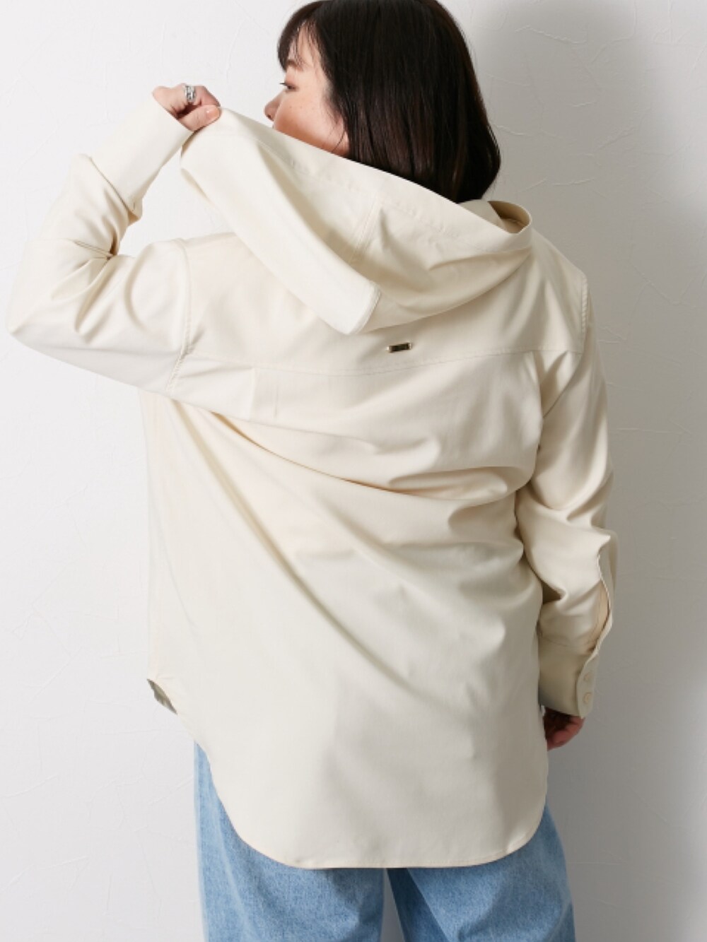 ベージュ系のシャツ/ブラウス、ブルー系のデニムパンツを着用したレディースの冬コーディネートの4枚目の写真