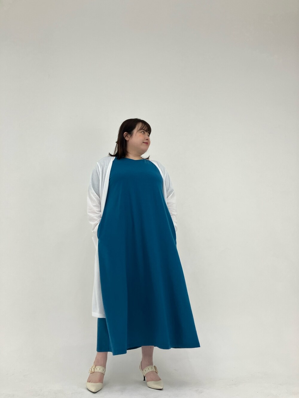 ホワイト系のカーディガン/ボレロ、ブルー系のワンピースを着用したレディースの春コーディネートの3枚目の写真