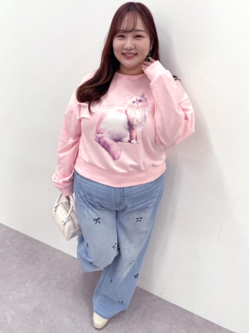 ピンク系のTシャツ/カットソー、ブルー系のデニムパンツを着用したレディースの冬コーディネートの3枚目の写真