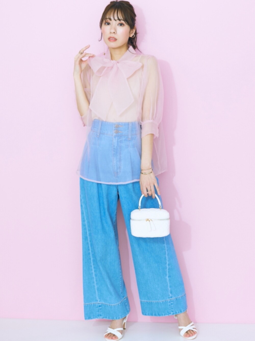 ピンク系のシャツ/ブラウス、ブルー系のデニムパンツを着用したレディースの春コーディネートの2枚目の写真