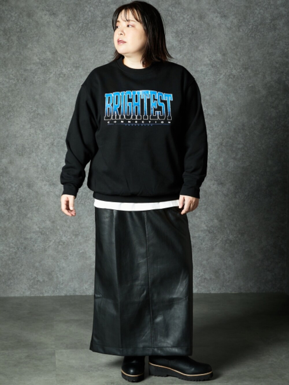 ブラック系のスウェット、ブラック系のスカートを着用したレディースの秋コーディネートの2枚目の写真