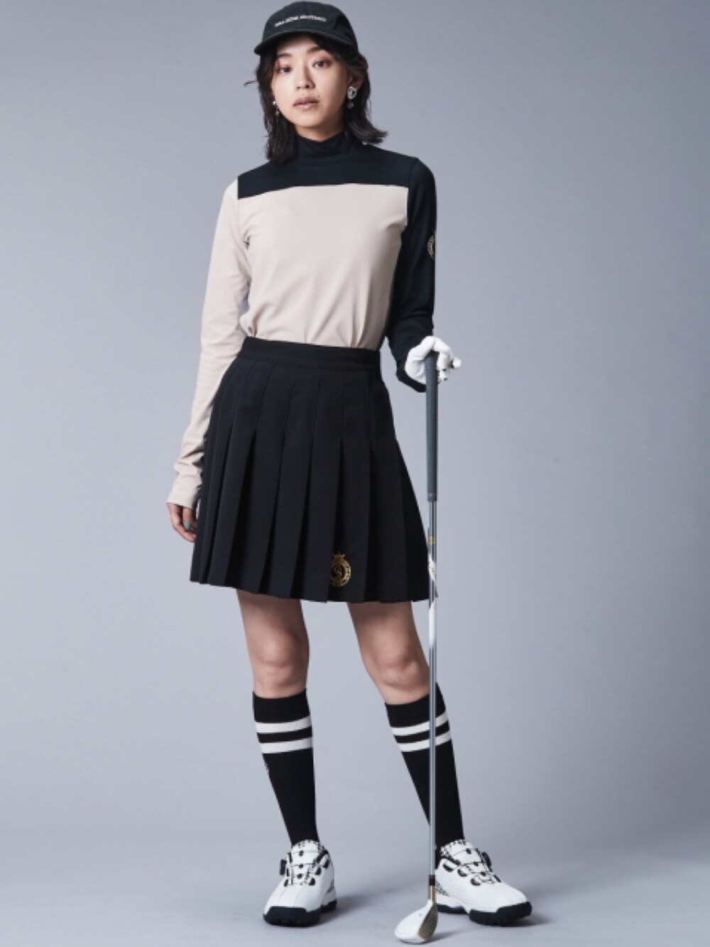 ブラック系のスカート、ベージュ系のTシャツ/カットソーを着用したレディースの夏コーディネートの2枚目の写真