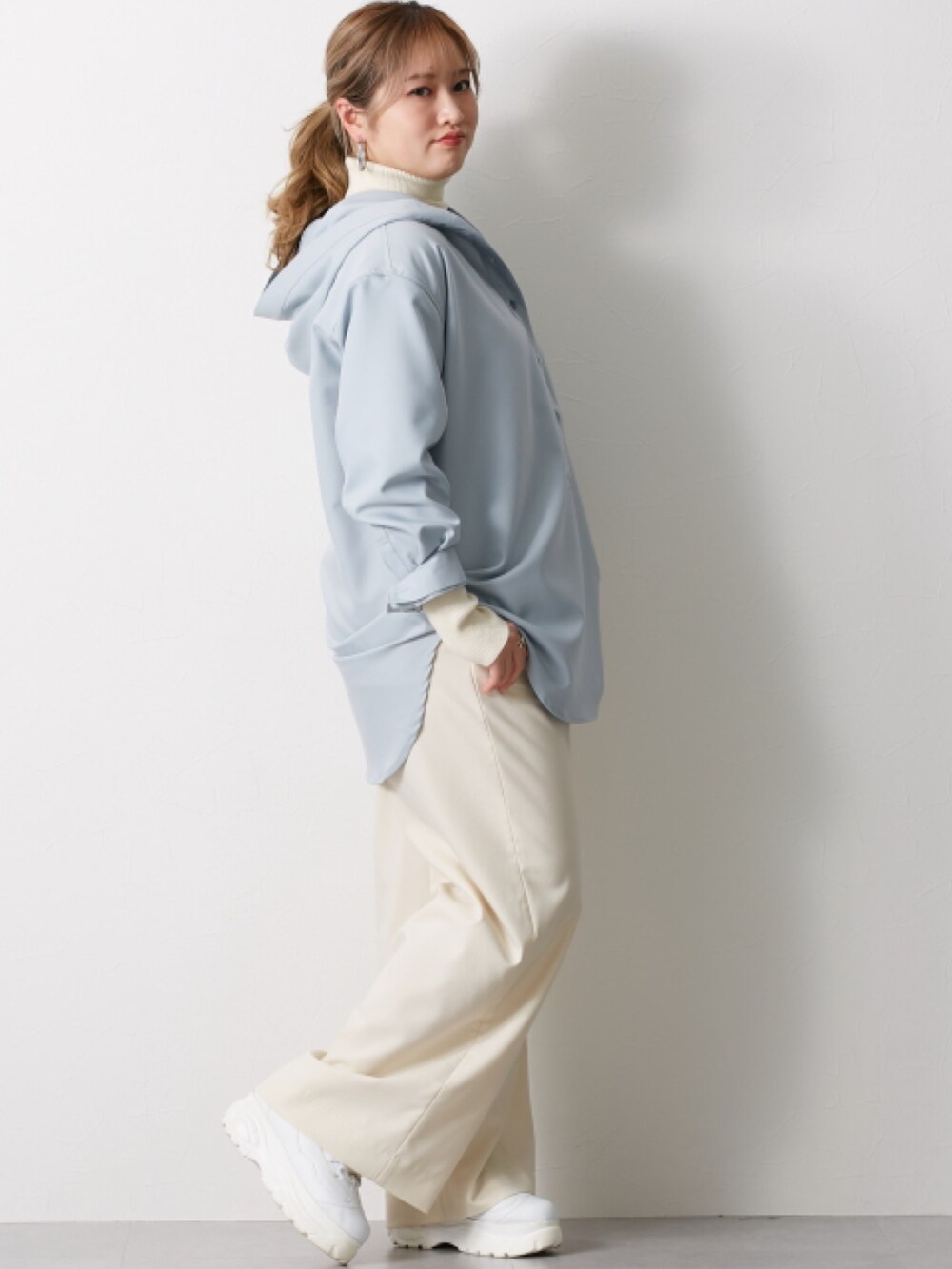 ホワイト系のニット/セーター、ベージュ系のシャツ/ブラウス、グレー系のパンツを着用したレディースの冬コーディネートの2枚目の写真