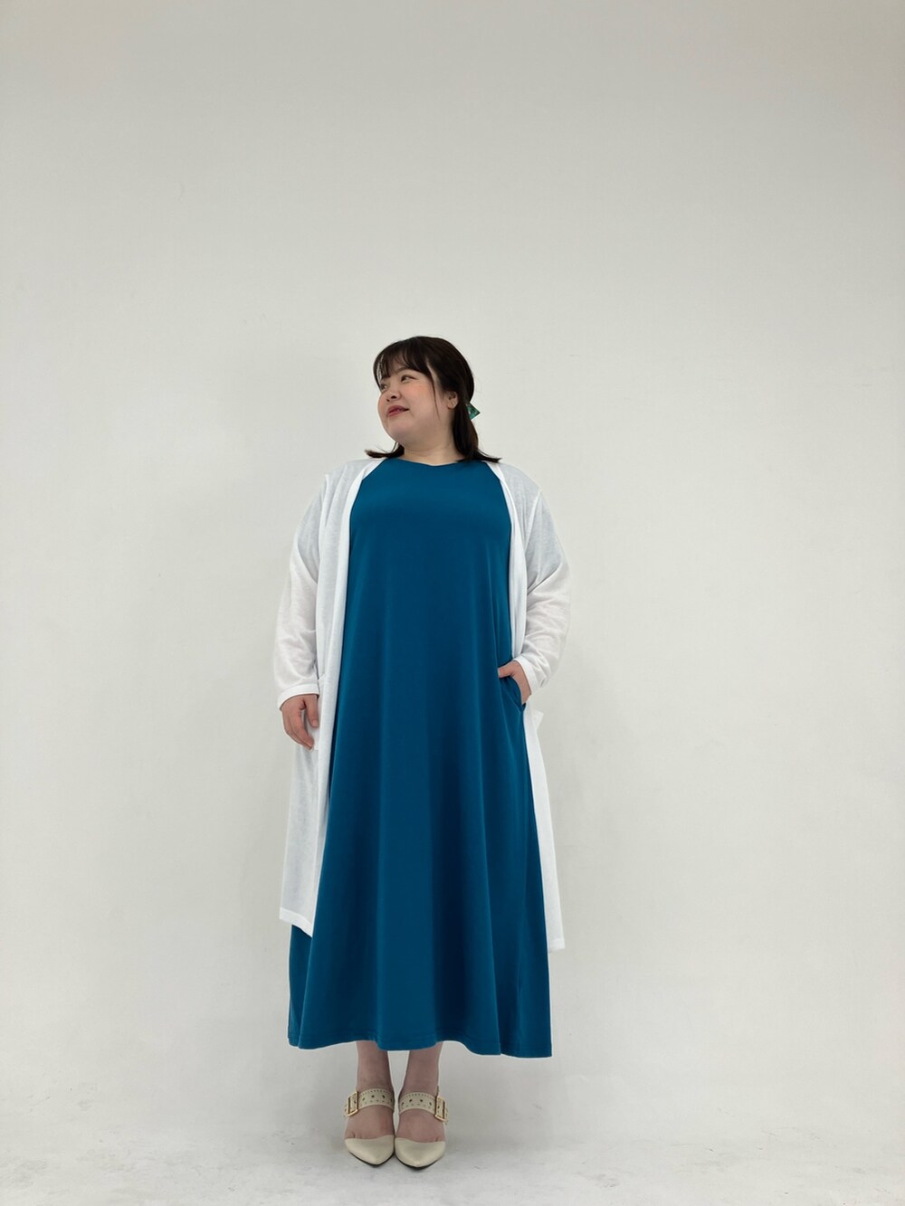 ホワイト系のカーディガン/ボレロ、ブルー系のワンピースを着用したレディースの春コーディネートの2枚目の写真