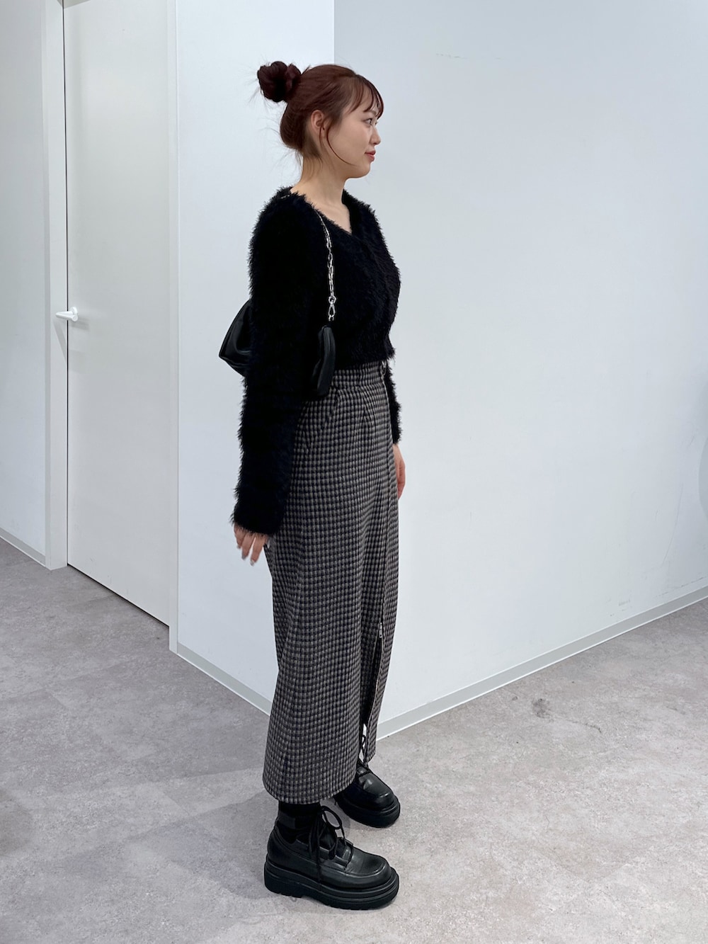 ブラック系のカーディガン/ボレロ、ベージュ系のスカート、ブラック系のハンドバッグを着用したレディースの冬コーディネートの2枚目の写真