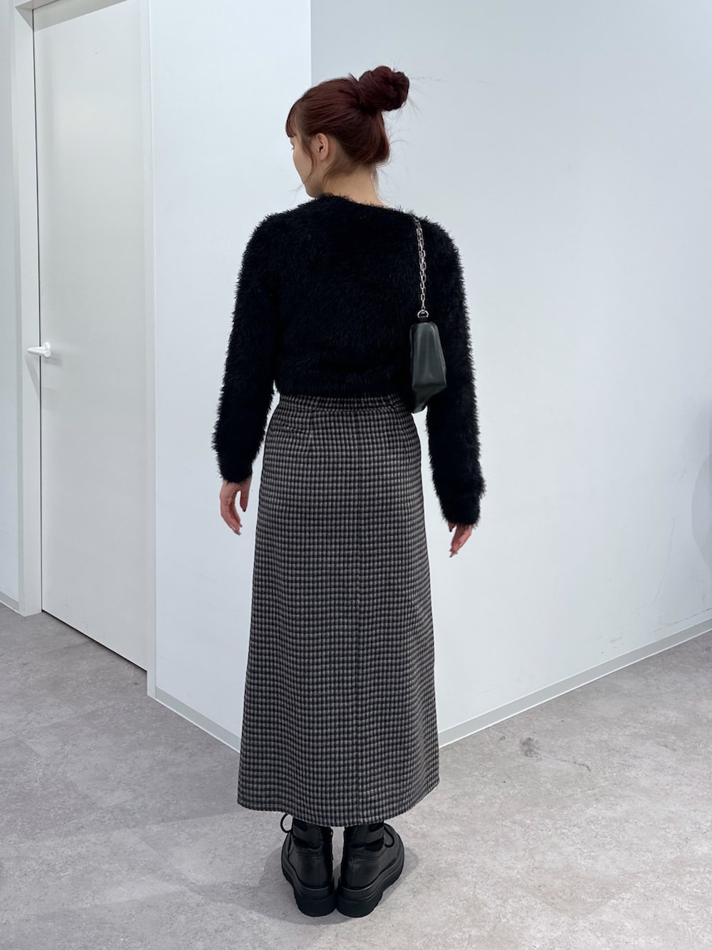 ブラック系のカーディガン/ボレロ、ベージュ系のスカート、ブラック系のハンドバッグを着用したレディースの冬コーディネートの3枚目の写真