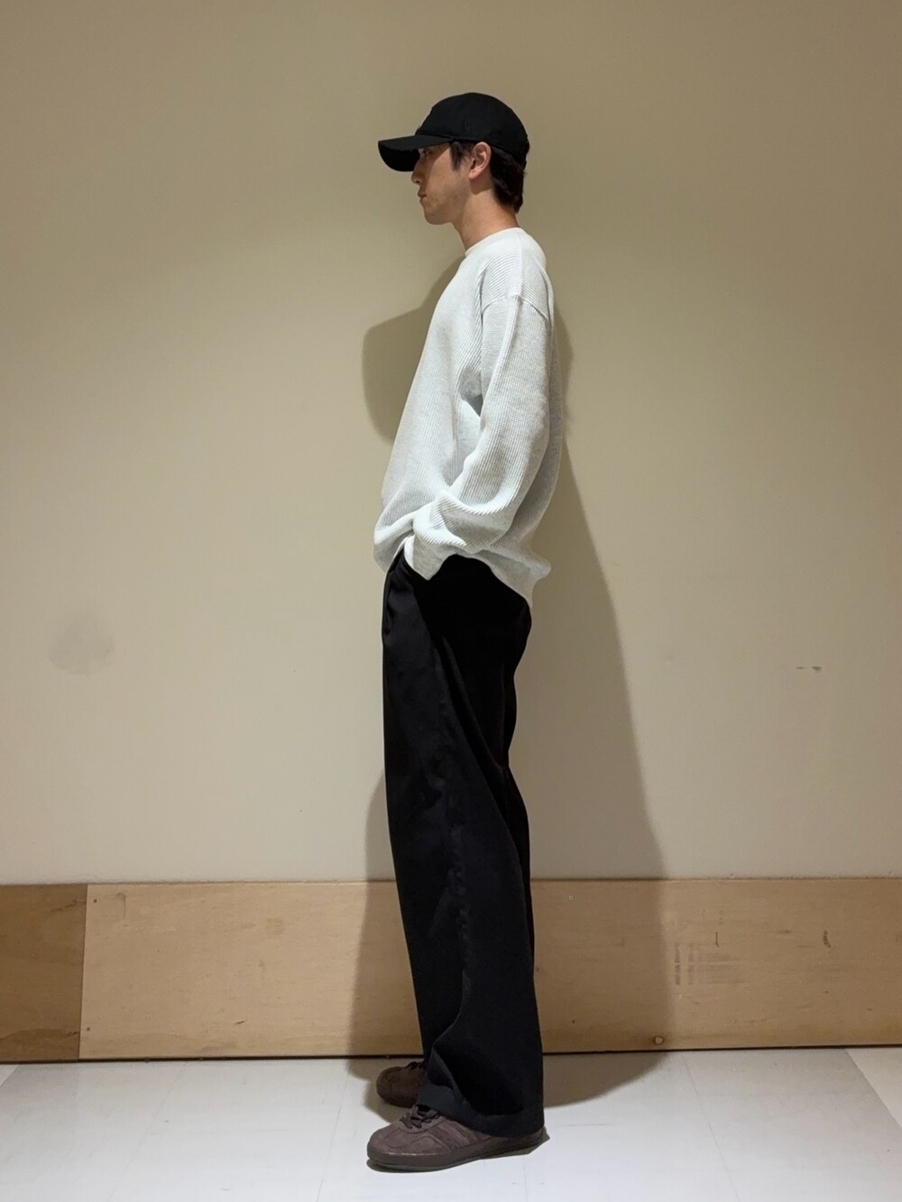 ブラウン系のスニーカー、ホワイト系のTシャツ/カットソー、ブラック系のキャップを着用したメンズの秋コーディネートの2枚目の写真