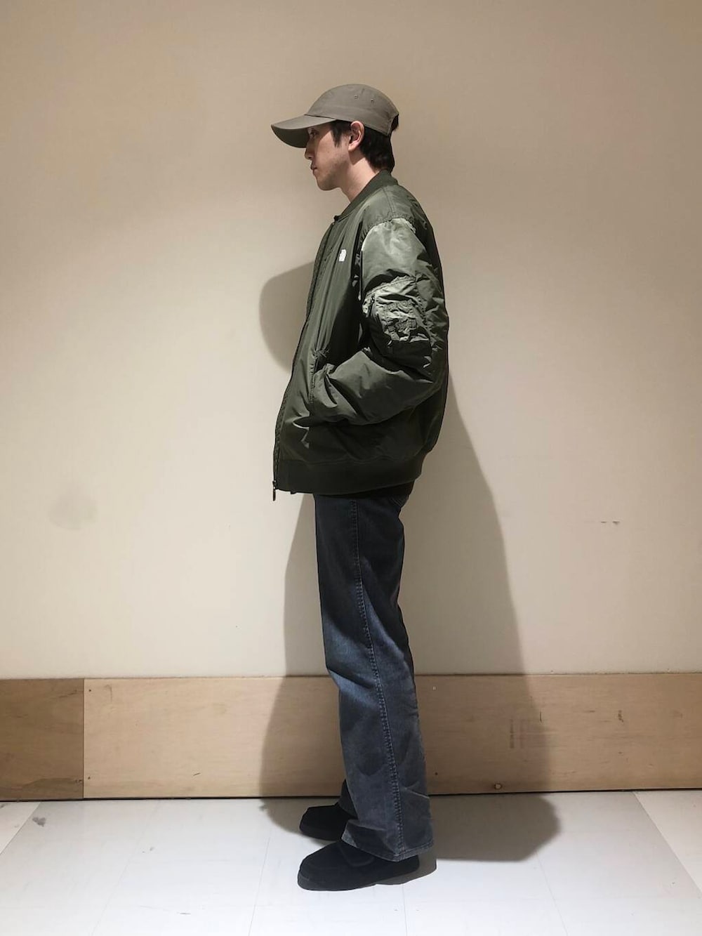 ブラウン系のポロシャツ、グリーン系のブルゾン、グリーン系のキャップを着用したメンズの冬コーディネートの2枚目の写真