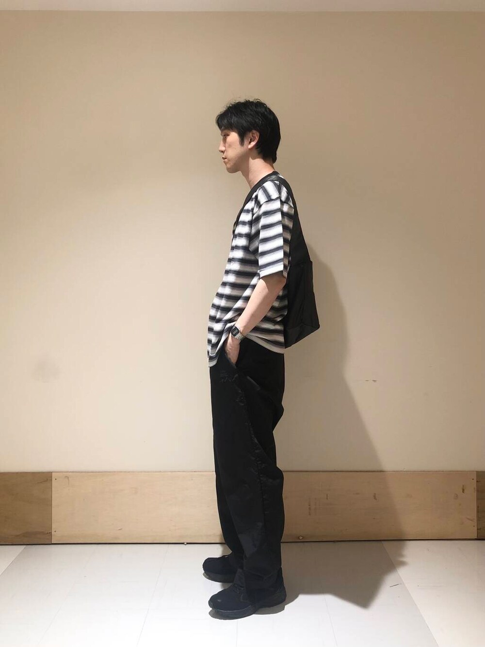 ブラック系のその他パンツ、ブラック系のスニーカー、グレー系のショルダーバッグを着用したメンズの夏コーディネートの2枚目の写真