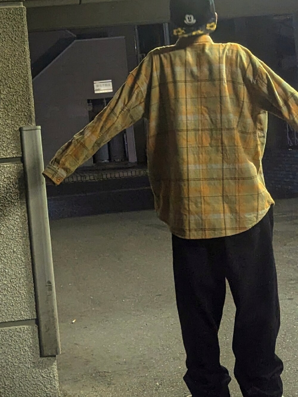 ブラック系のデニムパンツ、ホワイト系のスニーカー、イエロー系のシャツ/ブラウスを着用したメンズの秋コーディネートの2枚目の写真