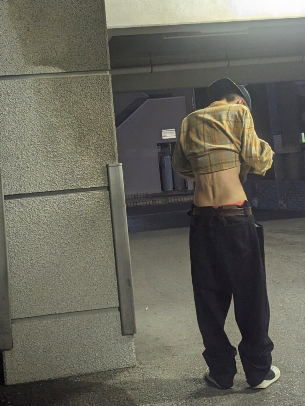 ブラック系のデニムパンツ、ホワイト系のスニーカー、イエロー系のシャツ/ブラウスを着用したメンズの秋コーディネートの3枚目の写真