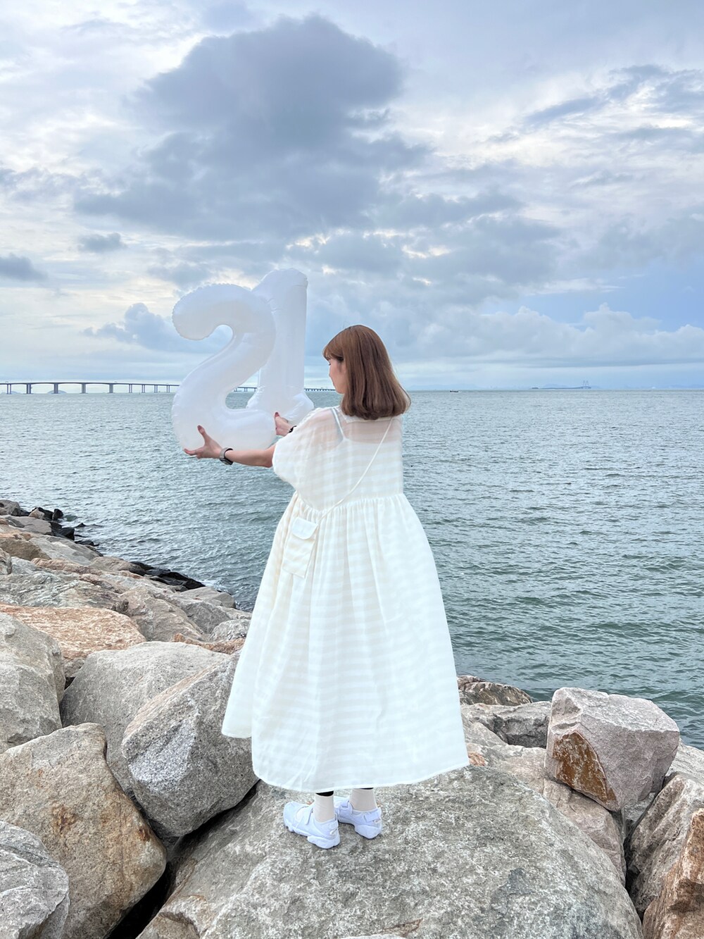 ホワイト系のワンピース、ホワイト系のスニーカーを着用したレディースの夏コーディネートの2枚目の写真