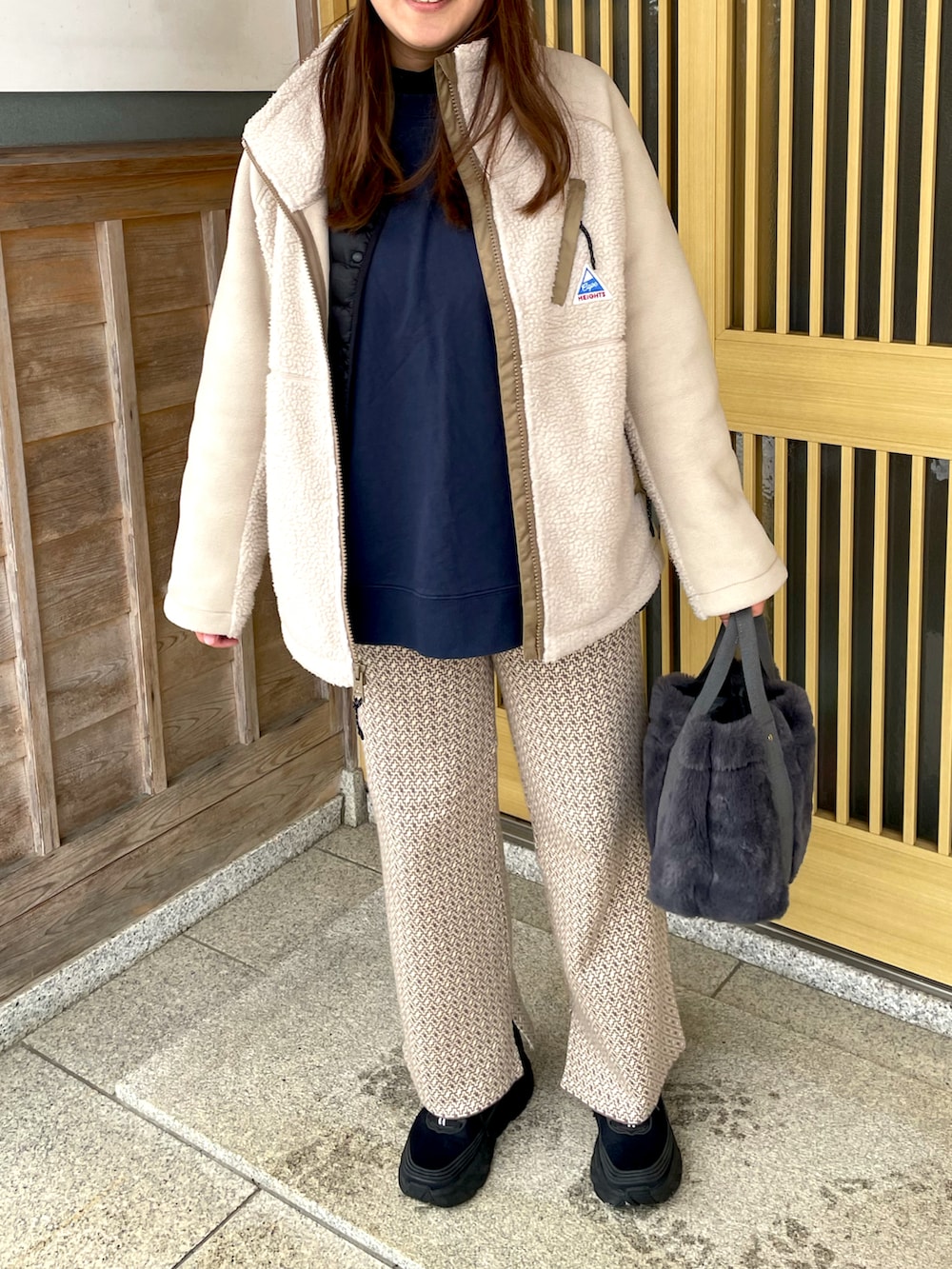 ベージュ系のブルゾン、ブラック系のスニーカー、ベージュ系のその他パンツを着用したレディースの冬コーディネートの2枚目の写真