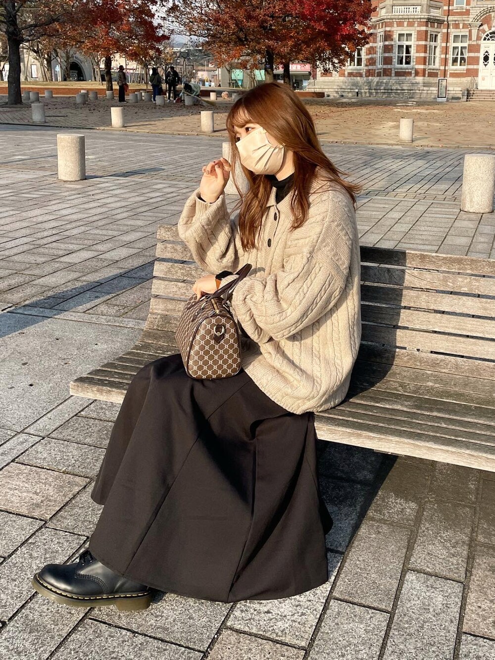 ブラック系のブーツ、ブラック系のスカート、ベージュ系のニット/セーターを着用したレディースの冬コーディネートの3枚目の写真