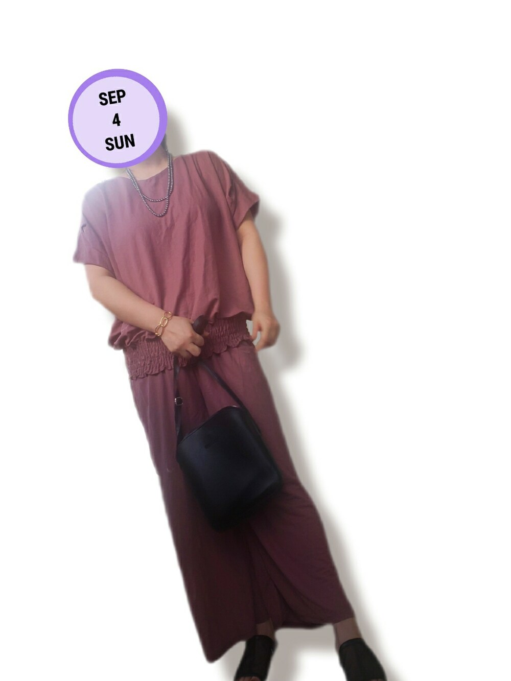 ピンク系のセットアップ、ブラック系のショルダーバッグ、ブラック系のサンダルを着用したレディースの秋コーディネートの2枚目の写真