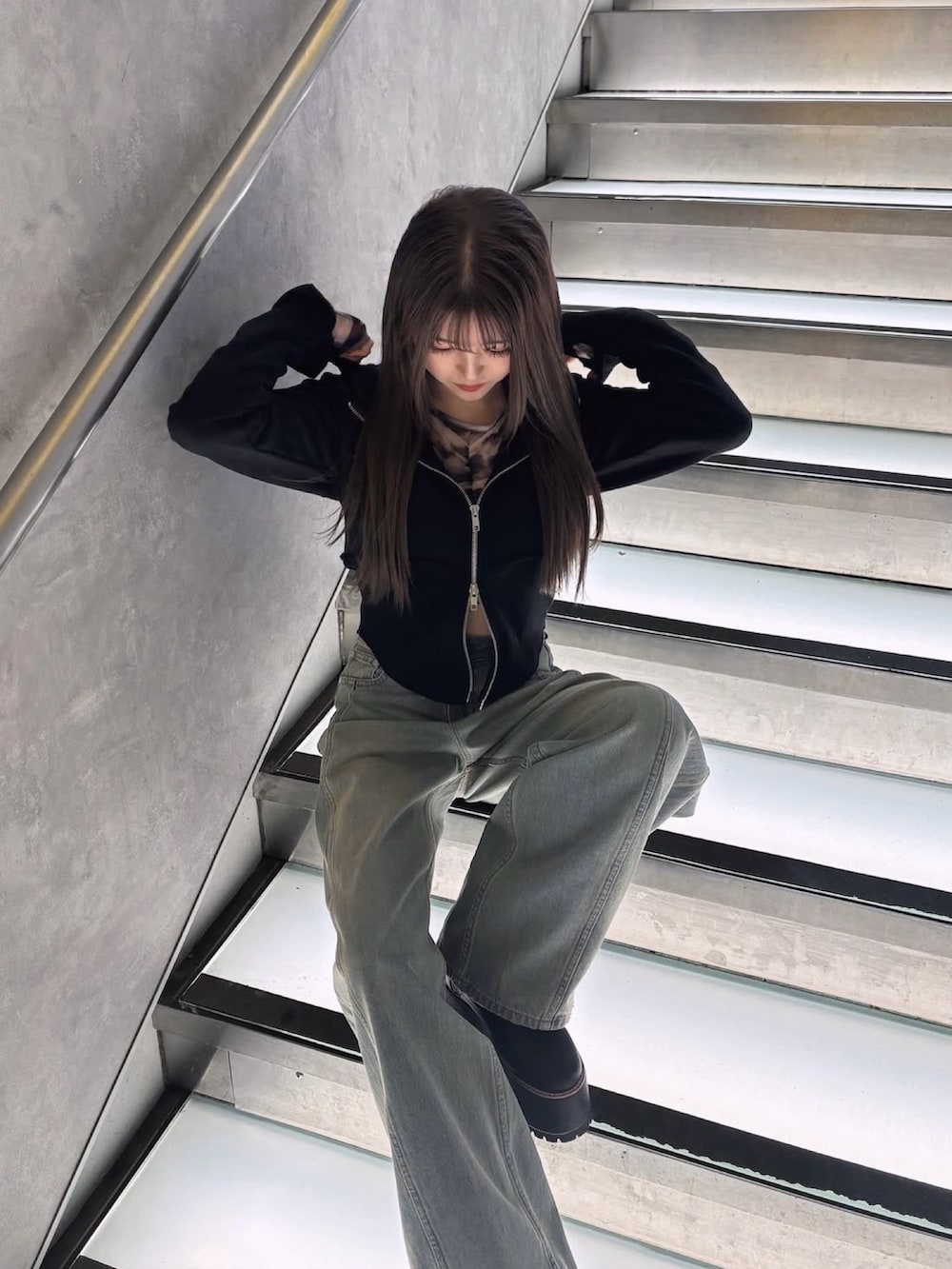 ブラック系のパーカー、グレー系のTシャツ/カットソー、ブルー系のデニムパンツを着用したレディースの冬コーディネートの4枚目の写真