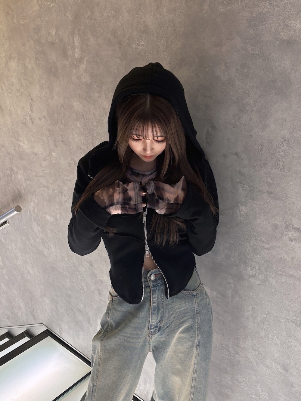 ブラック系のパーカー、グレー系のTシャツ/カットソー、ブルー系のデニムパンツを着用したレディースの冬コーディネートの2枚目の写真