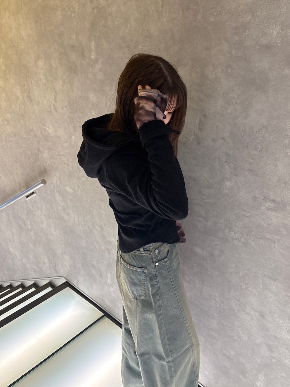 ブラック系のパーカー、グレー系のTシャツ/カットソー、ブルー系のデニムパンツを着用したレディースの冬コーディネートの3枚目の写真