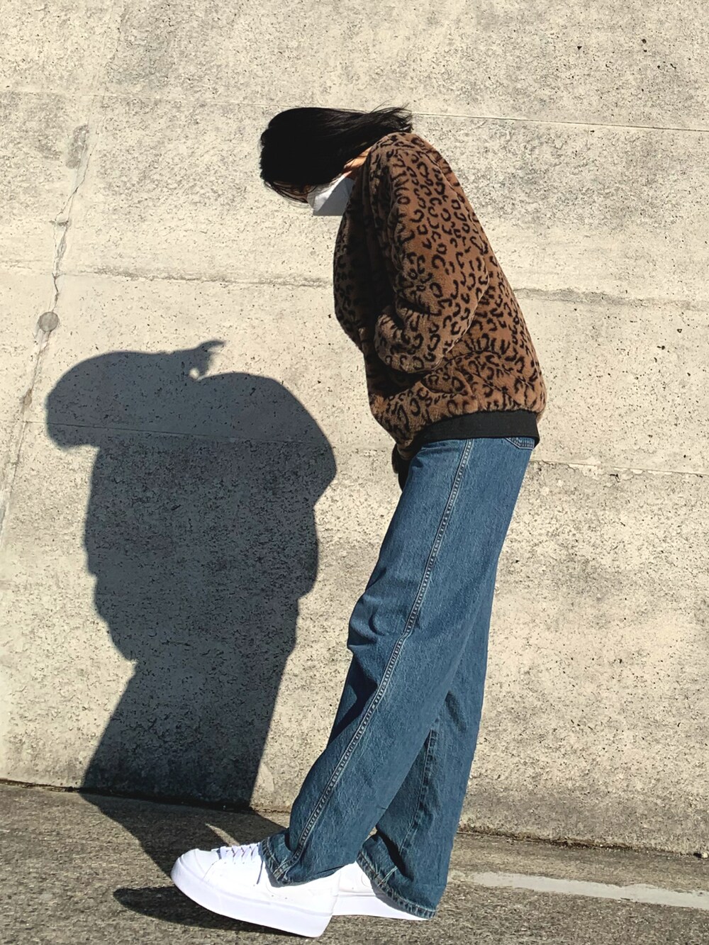 ブルー系のデニムパンツ、ホワイト系のスニーカーを着用したレディースの冬コーディネートの3枚目の写真