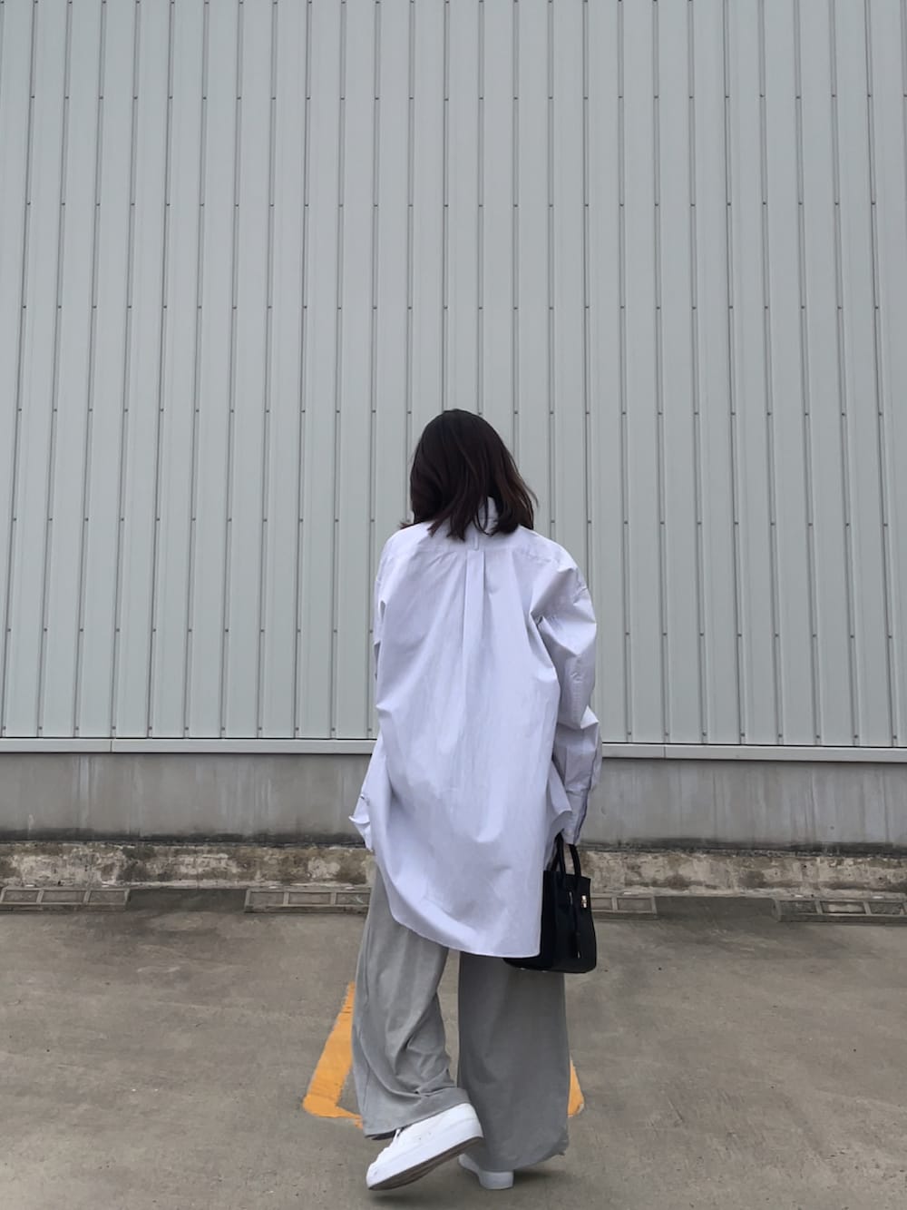 グレー系のキャミソール、ホワイト系のスニーカー、ブラック系のバッグを着用したレディースの春コーディネートの3枚目の写真