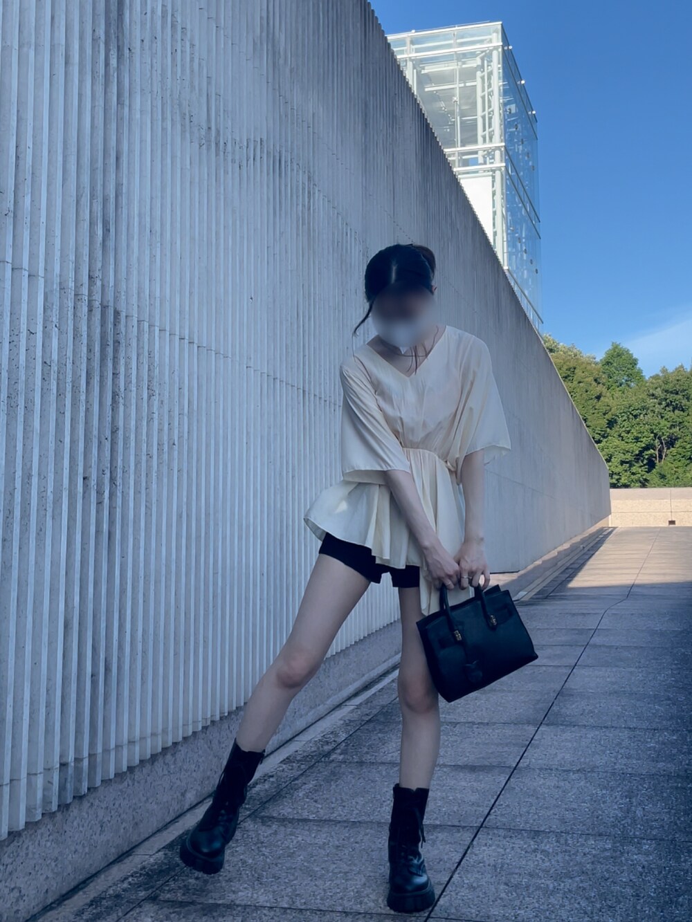 ブラック系のバッグ、ブラック系のパンツ、シルバー系のネックレスを着用したレディースの夏コーディネートの2枚目の写真