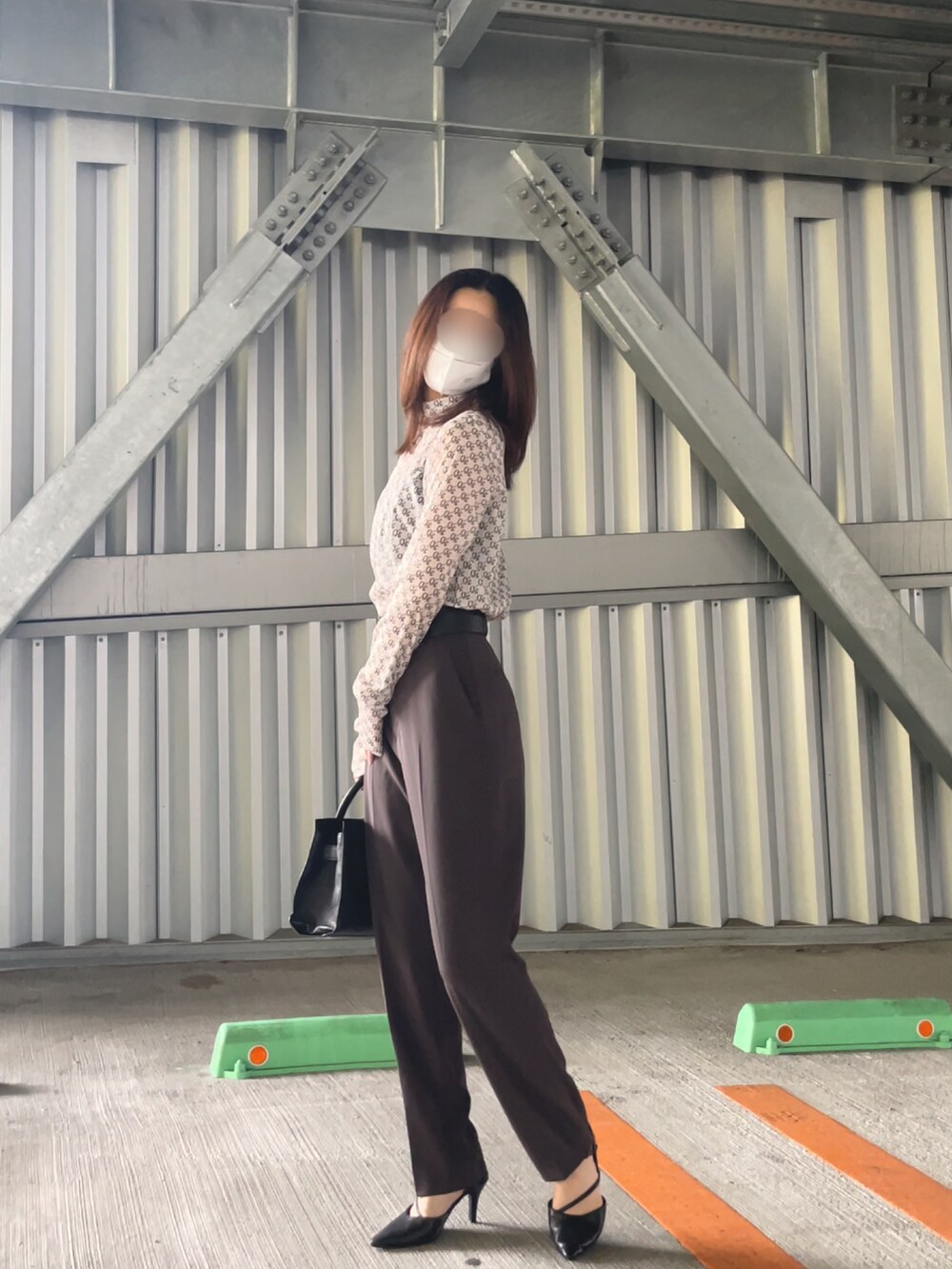 ホワイト系のトップス、ブラウン系のスラックス、ブラック系のシューズを着用したレディースの夏コーディネートの2枚目の写真