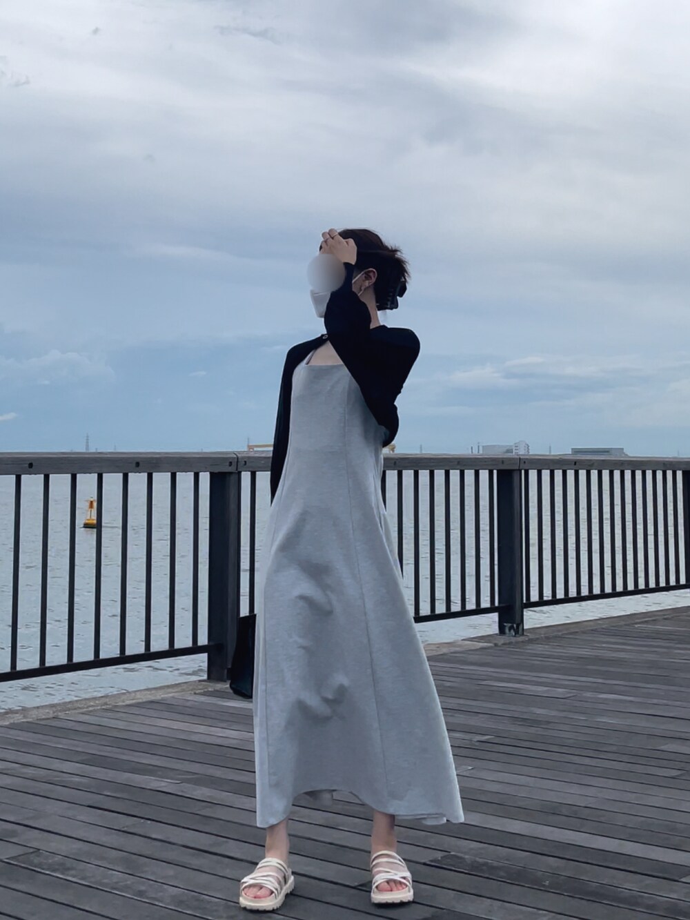 ブラック系のバッグ、グレー系のワンピース、グレー系のキャミソールを着用したレディースの夏コーディネートの2枚目の写真