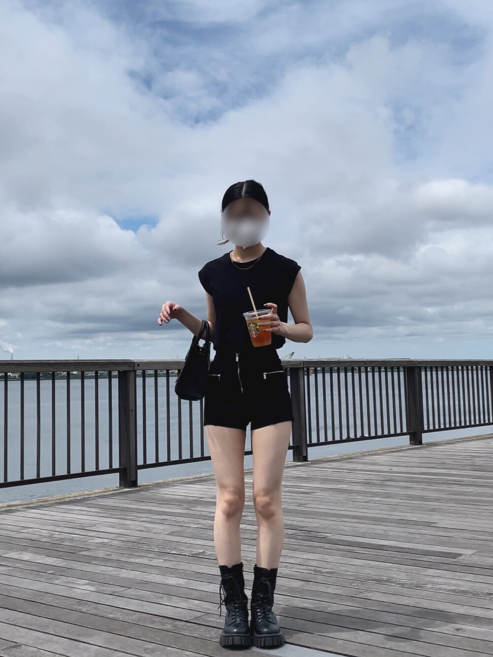 ブラック系のパンツ、ブラック系のバッグを着用したレディースの夏コーディネートの2枚目の写真