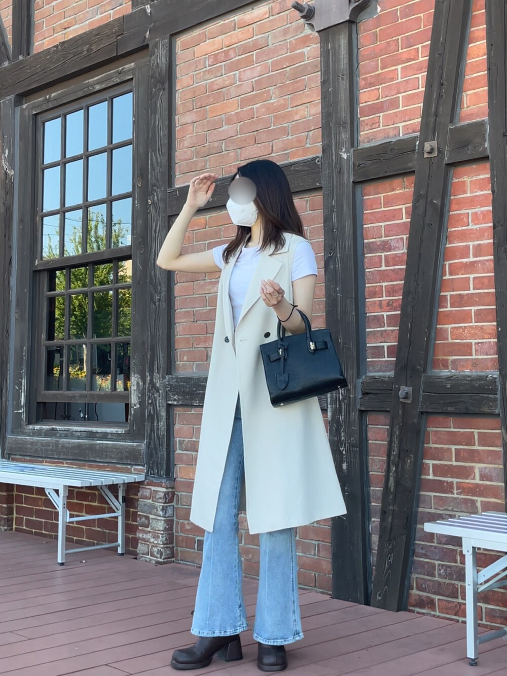 ブラック系のバッグ、ホワイト系のトップス、ベージュ系のジャケット/アウターを着用したレディースの夏コーディネートの3枚目の写真