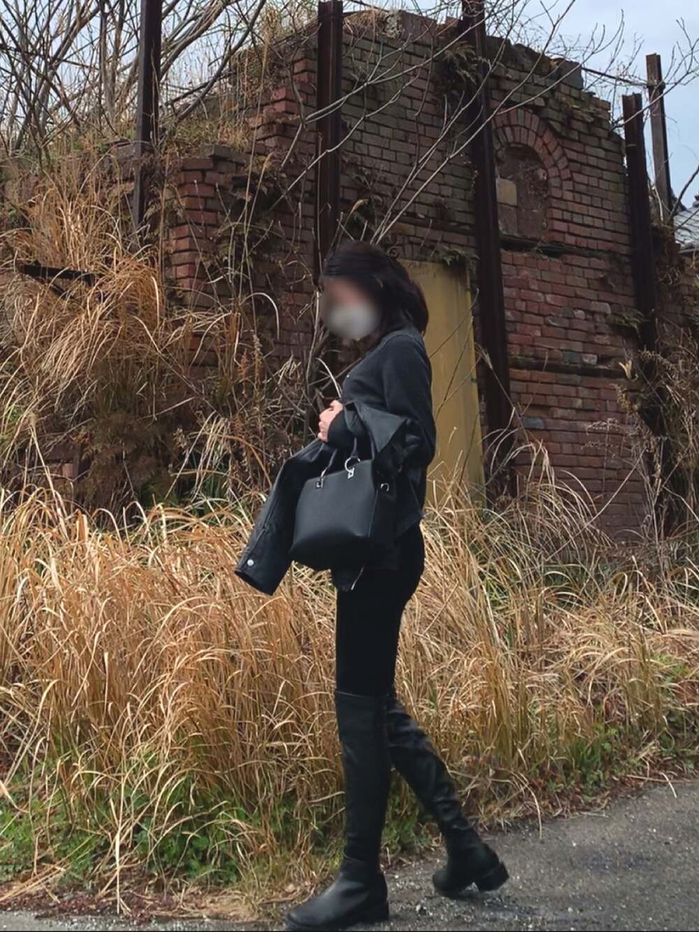 ブラック系のライダースジャケット、グレー系のニット/セーター、ブラック系のパンツを着用したレディースの春コーディネートの3枚目の写真