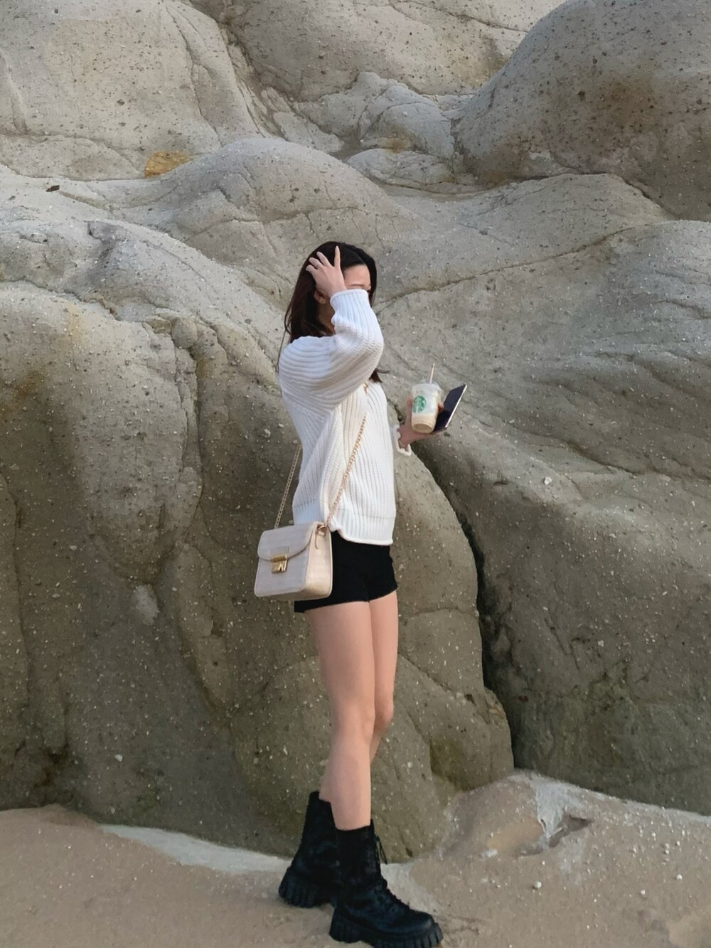 ホワイト系のニット/セーター、ブラック系のパンツを着用したレディースの冬コーディネートの2枚目の写真