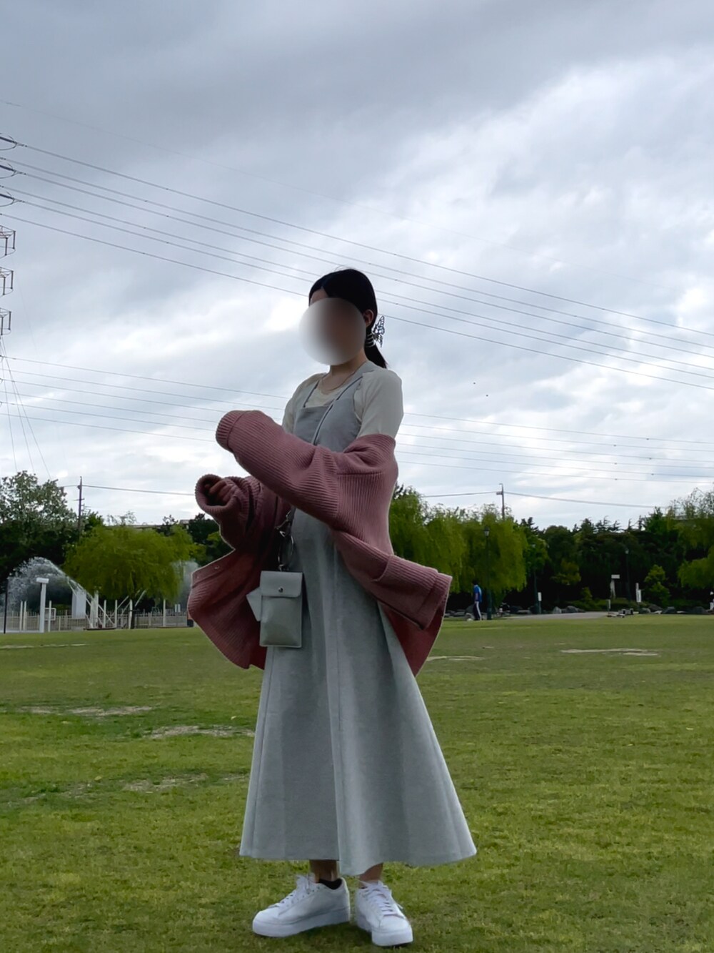 グレー系のワンピース、ピンク系のカーディガン/ボレロ、ホワイト系のスニーカーを着用したレディースの春コーディネートの3枚目の写真