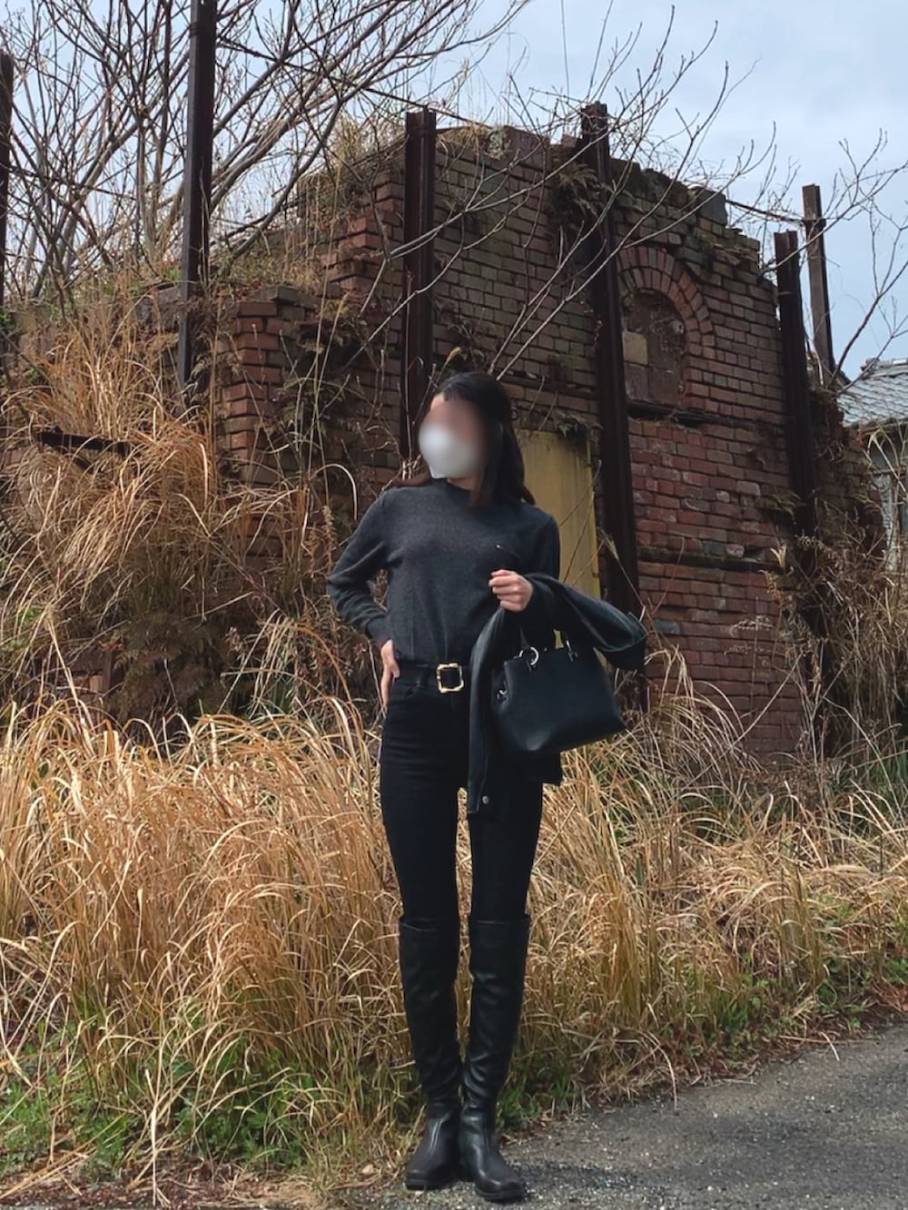 ブラック系のライダースジャケット、グレー系のニット/セーター、ブラック系のパンツを着用したレディースの春コーディネートの2枚目の写真