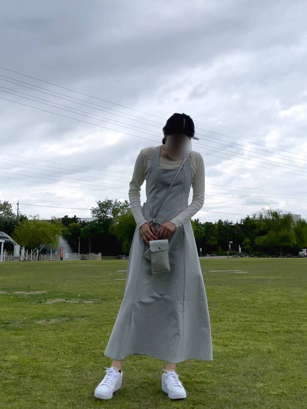 グレー系のワンピース、ピンク系のカーディガン/ボレロ、ホワイト系のスニーカーを着用したレディースの春コーディネートの4枚目の写真