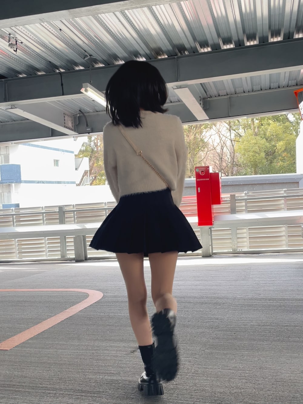 ホワイト系のニット/セーター、ブラック系のスカートを着用したレディースの冬コーディネートの2枚目の写真