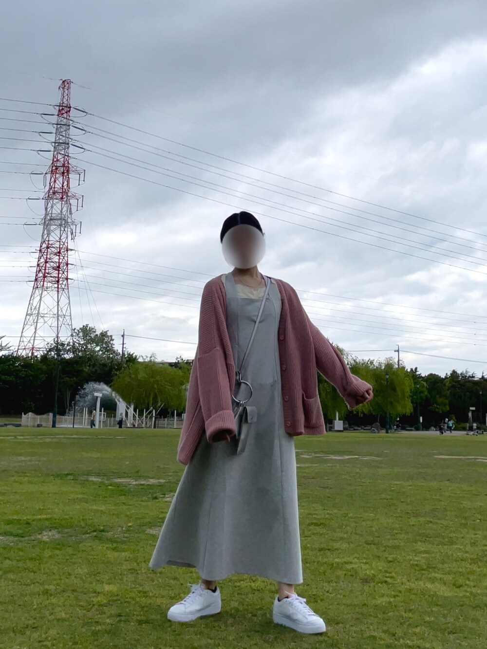 グレー系のワンピース、ピンク系のカーディガン/ボレロ、ホワイト系のスニーカーを着用したレディースの春コーディネートの2枚目の写真