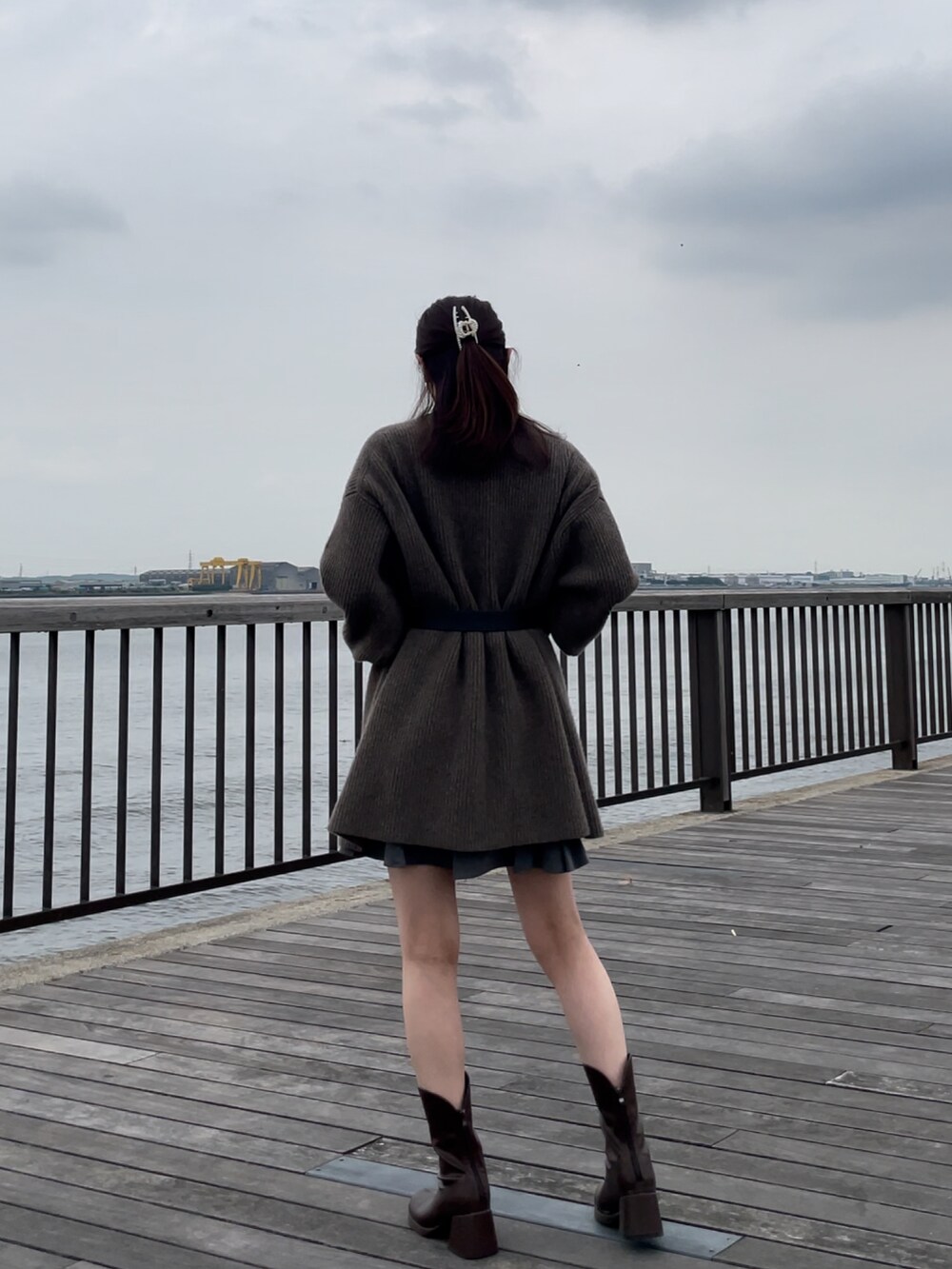 ブラウン系のカーディガン/ボレロ、ホワイト系のTシャツ/カットソー、グレー系のスカートを着用したレディースの秋コーディネートの2枚目の写真