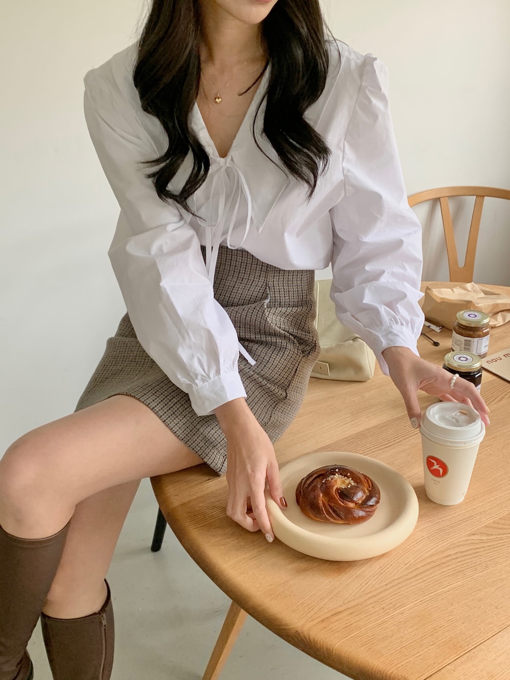 ホワイト系のシャツ/ブラウス、ブルー系のスカート、ブラウン系のブーツを着用したレディースの冬コーディネートの2枚目の写真