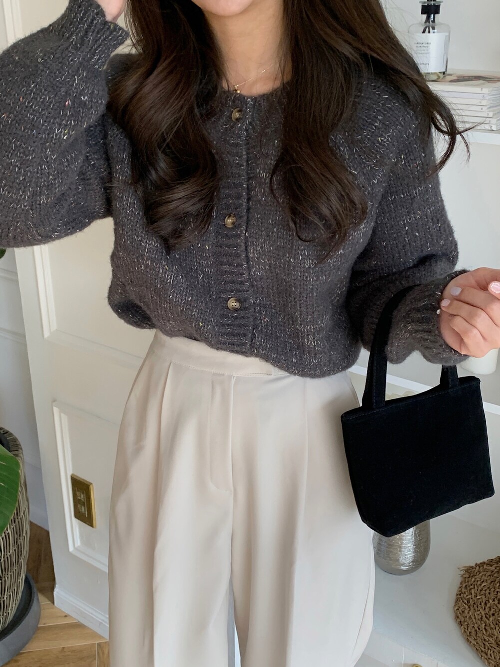 ブラック系のバレエシューズ、ホワイト系のスラックス、グレー系のカーディガン/ボレロを着用したレディースの冬コーディネートの2枚目の写真